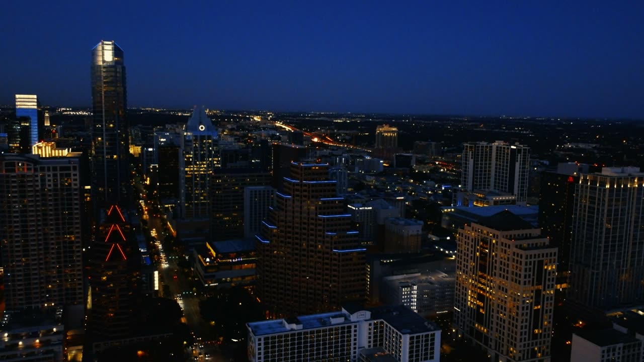 Aerial view of a city at night, lights glowing gold
